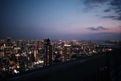 Illuminated buildings in city against sky at night