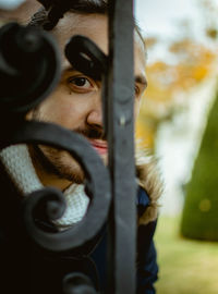 Young guy portrait hiding behind a metal fence - copy space