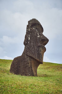Moai stone structure on field against sky