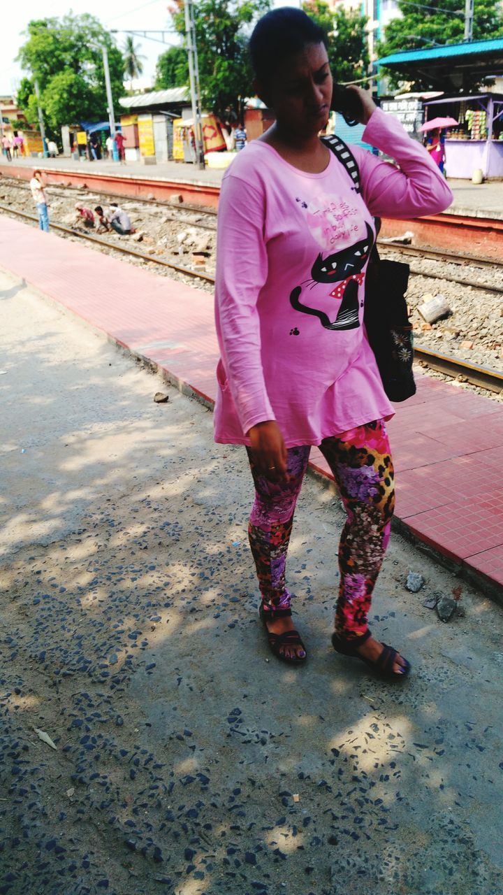 FULL LENGTH OF WOMAN STANDING ON PINK ROAD