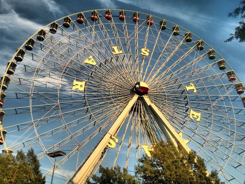 ferris wheel, amusement park, amusement park ride, arts culture and entertainment, low angle view, sky, circle, big wheel, cloud - sky, fairground, day, large, outdoors, fairground ride, no people, metal, fun, built structure, blue, wheel