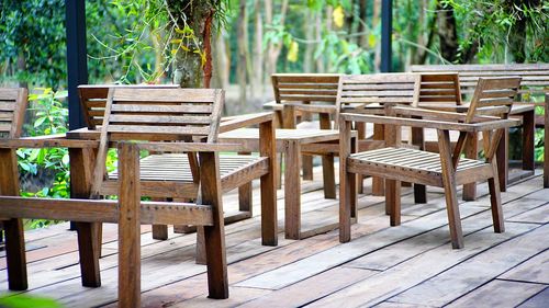 Empty chairs and table against trees