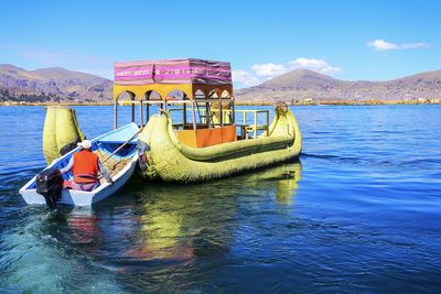 Boat moored in sea against blue sky