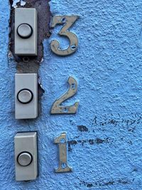 3 flat buzzers on a blue distressed wall labelled 3 2 1 