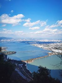 High angle view of city and sea against sky