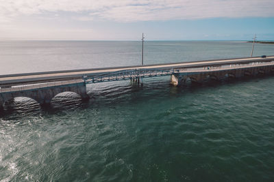 Pier over sea against sky during sunset