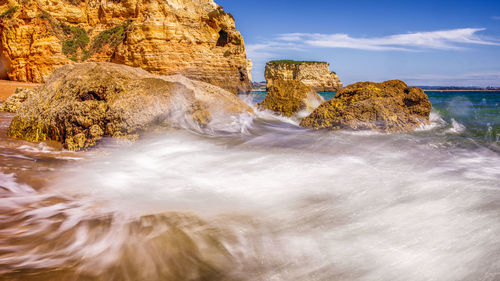 Scenic view of rocks in sea against sky