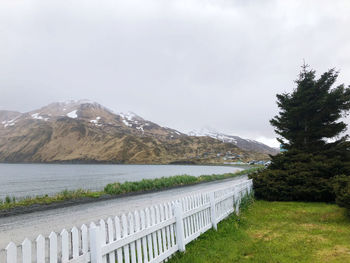 Scenic view of lake by mountain against sky