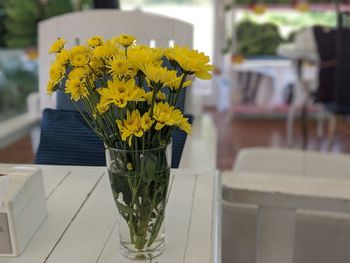 Close-up of yellow flower pot on table