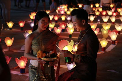 Young couple with illuminated lanterns at night