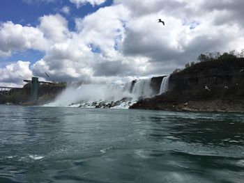 Scenic view of waterfall against sky