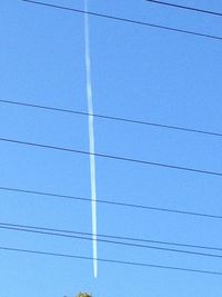 Low angle view of power lines against blue sky