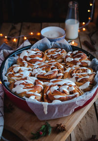 Homemade cinnamon rolls with cream cheese icing, on wooden background