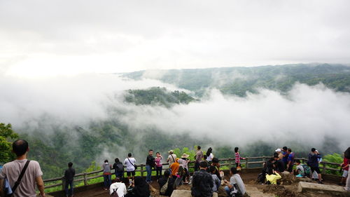 People on mountain against sky