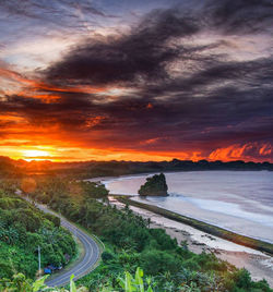 Scenic view of landscape against dramatic sky during sunset