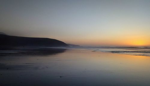 Scenic view of sea against clear sky during sunset