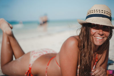 Beautiful young woman lying on beach