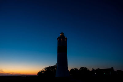 Low angle view of lighthouse against sky at sunset