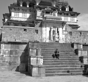 Man sitting on steps of historic building