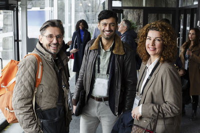 Portrait of business delegates standing in lobby during seminar at conference center