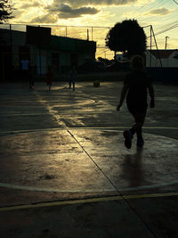 Silhouette people walking on street in city