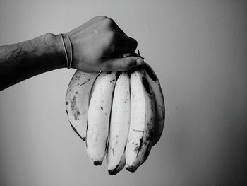 Close-up of hand holding ice cream over white background