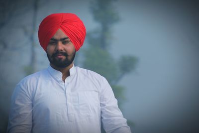 Portrait of young man standing during foggy weather