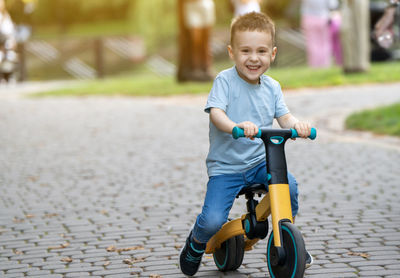 Portrait of cute baby boy walking on footpath
