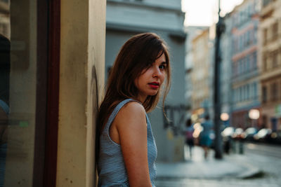 Portrait of beautiful young woman standing in city