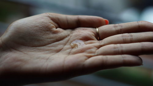 Cropped hand holding water drop