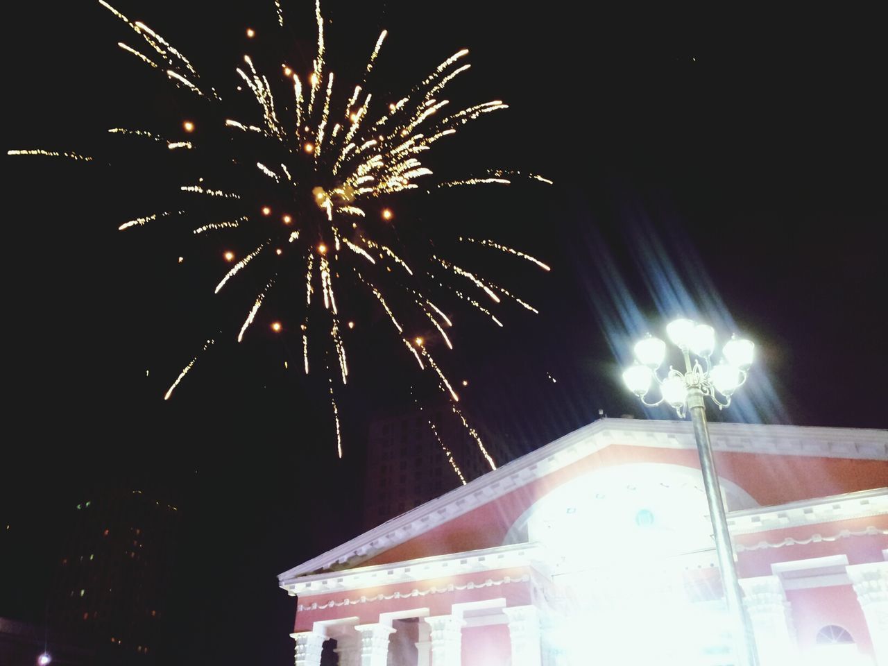 night, illuminated, firework display, low angle view, arts culture and entertainment, long exposure, celebration, exploding, firework - man made object, motion, built structure, architecture, building exterior, sky, event, glowing, sparks, blurred motion, entertainment, firework