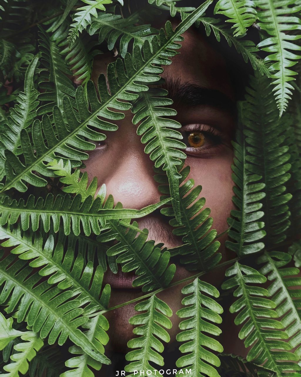 CLOSE-UP PORTRAIT OF MAN WITH LEAVES
