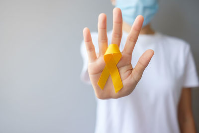 Close-up of hand holding yellow flower