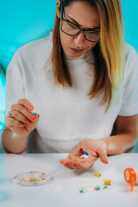 Confused woman holding medicines in her hand. medicine non adherence.