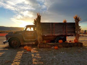 Car on land against sky during sunset