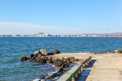 Scenic view of sea and buildings against blue sky