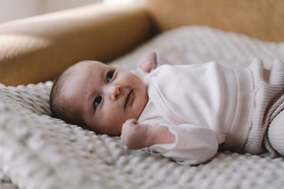 Portrait of a 1 month old baby. cute newborn baby lying on a developing rug.