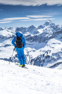 Rear view of person on snowcapped mountain