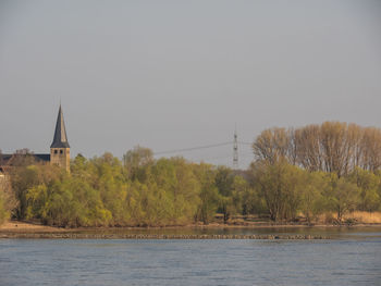 Scenic view of river by trees against sky