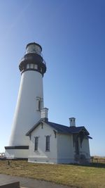Low angle view of lighthouse by building against sky