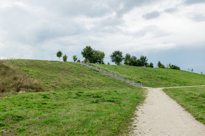 Road amidst field against sky