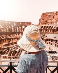 Rear view of woman wearing hat against built structure