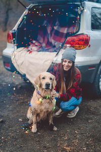 Portrait of woman with dog sitting outdoors