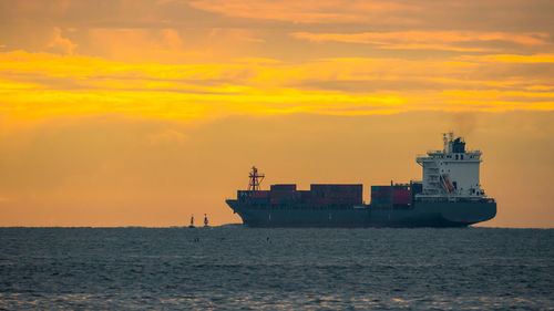 Ship sailing on sea against sky during sunset