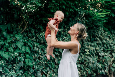 A happy laughing mother throws her cheerful baby. family bonding. maternal care.