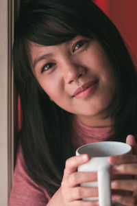 Portrait of young woman drinking coffee cup