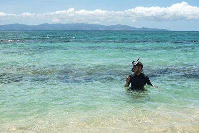 Man standing in sea against sky