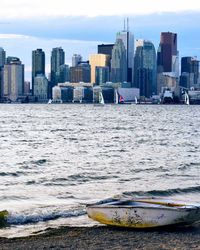 Boat in sea with city in background