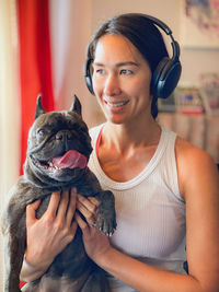 Portrait of happy woman with dog at home