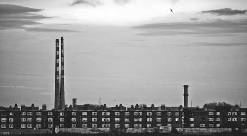 View of factory against cloudy sky